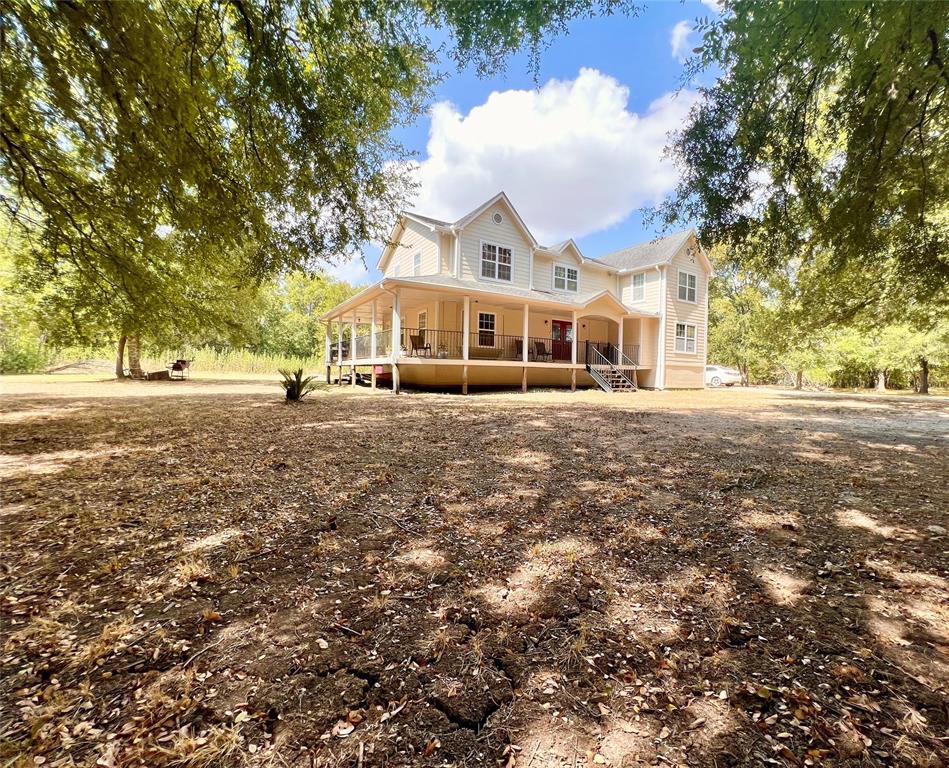 a view of a white house with a big yard and large trees