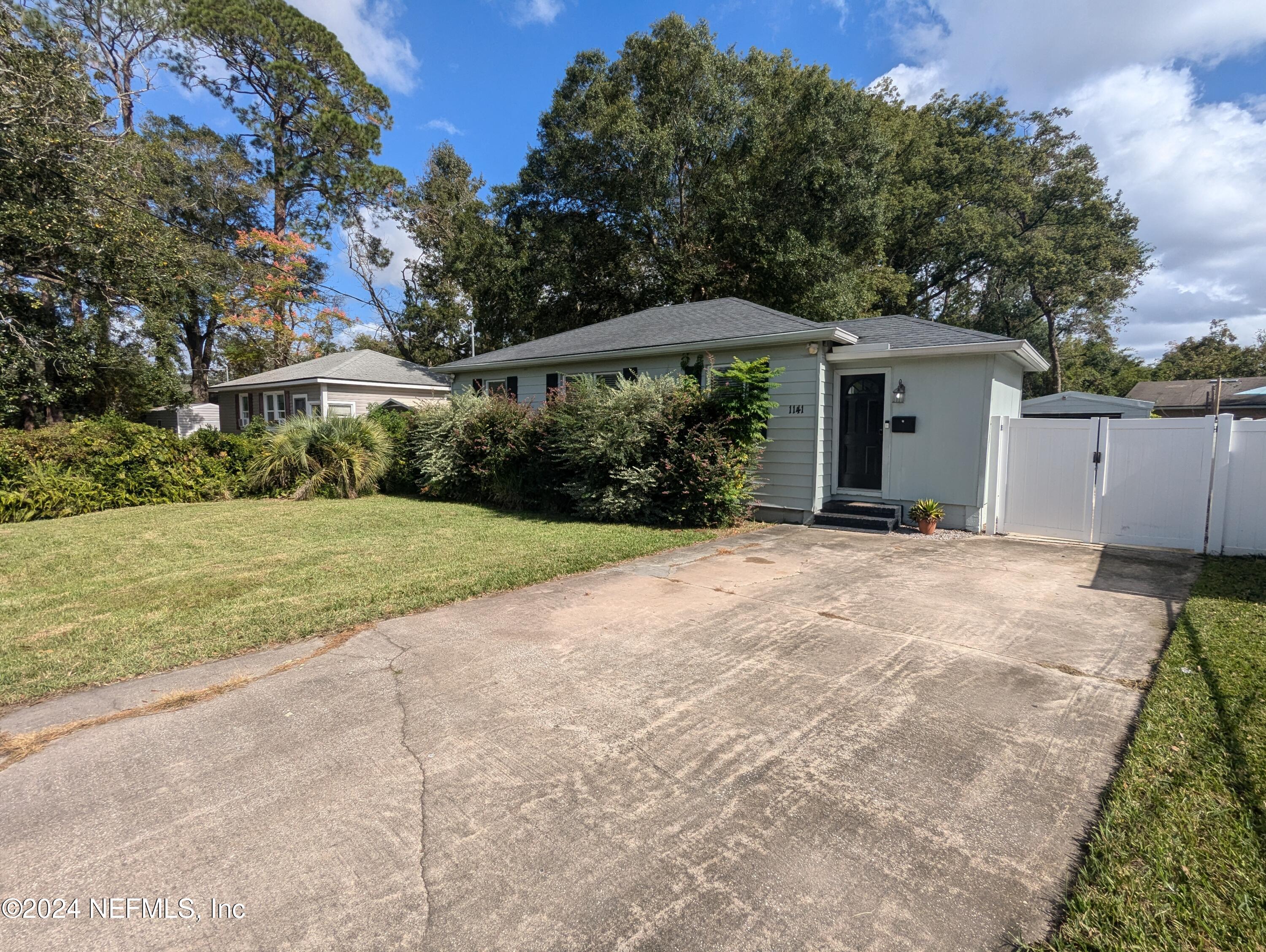 a view of a house with backyard and trees