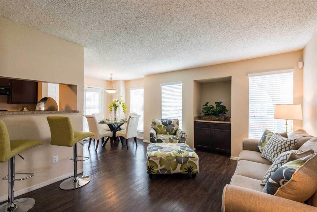 a living room with furniture wooden floor and a large window