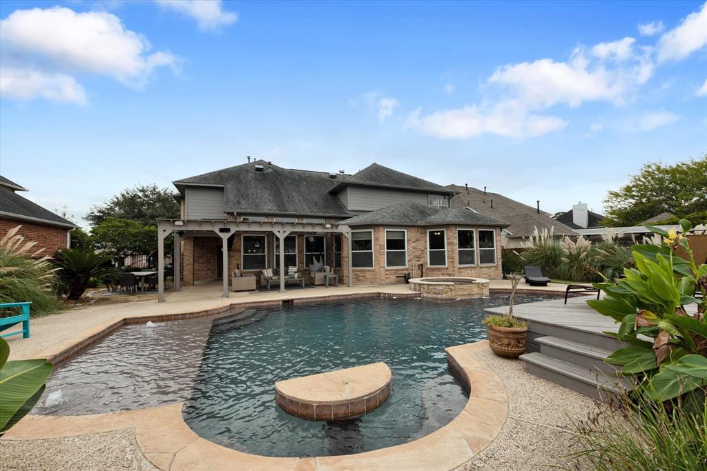 a view of a house with swimming pool and sitting area