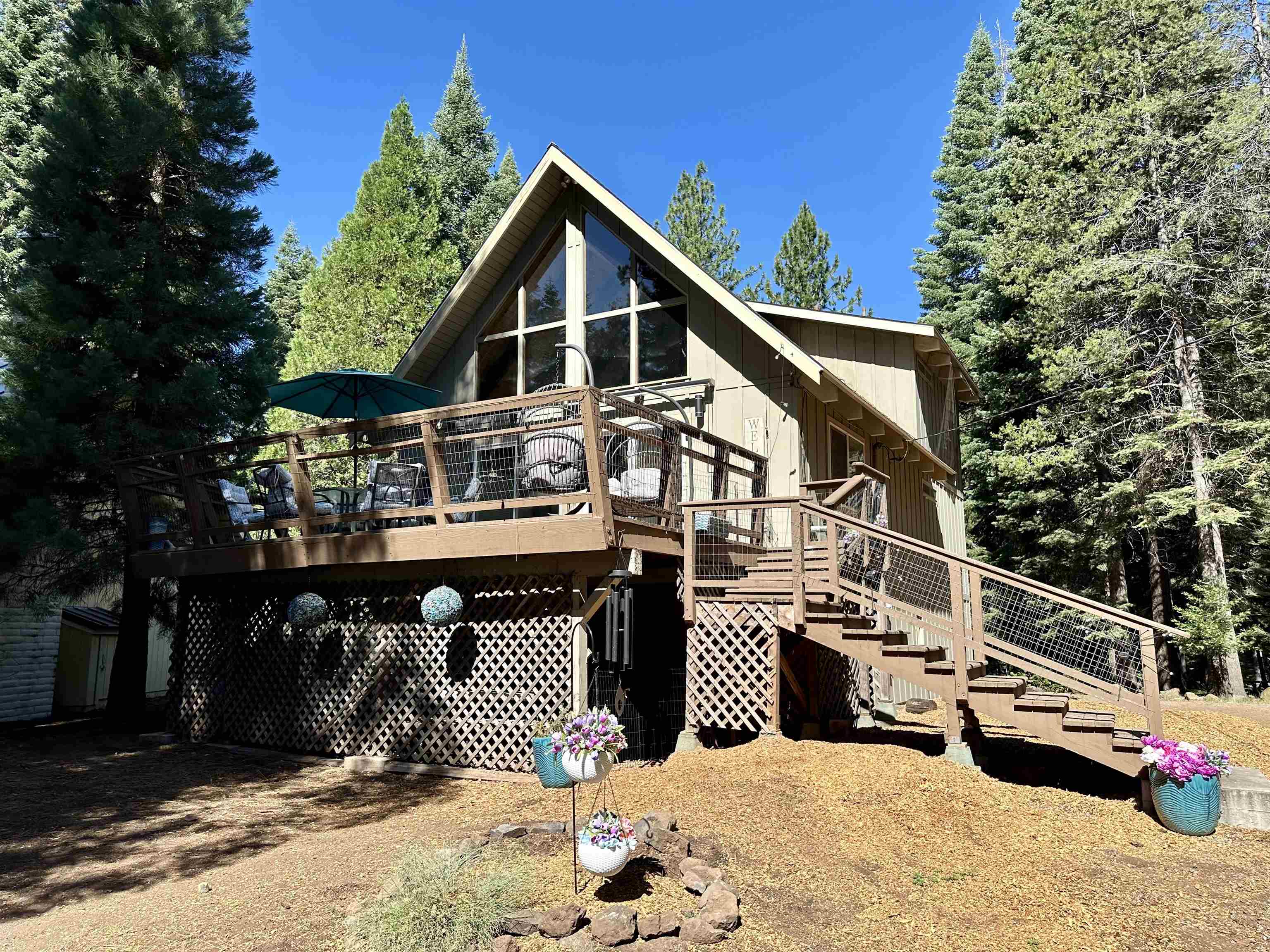 a view of a house with a wooden roof deck