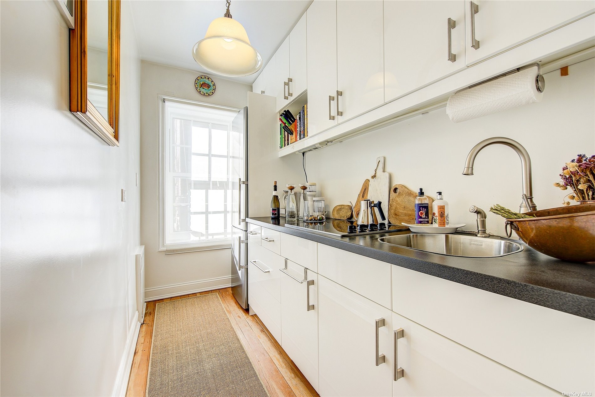 a kitchen with sink a window and cabinets