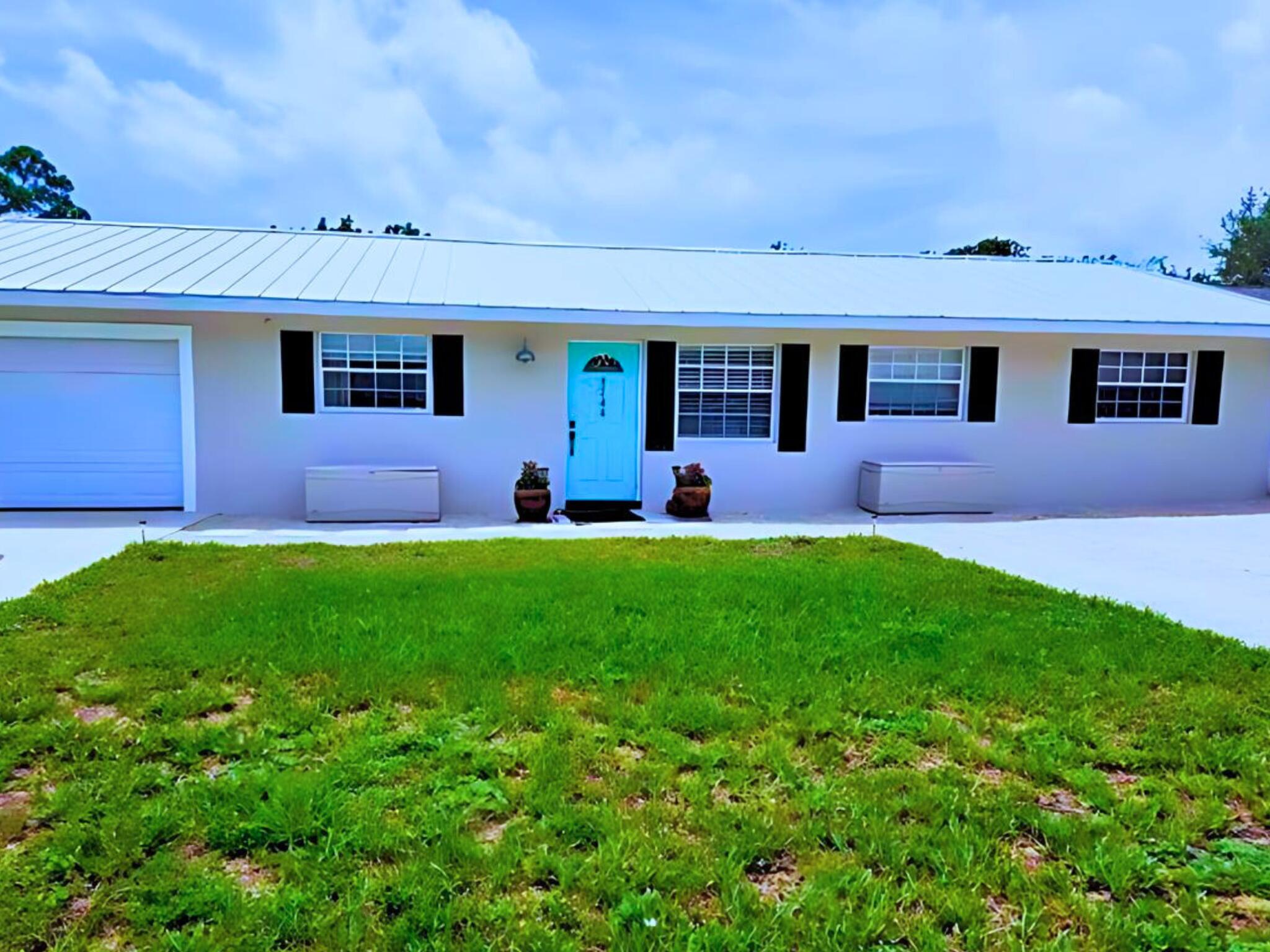 a front view of a house with a garden and yard