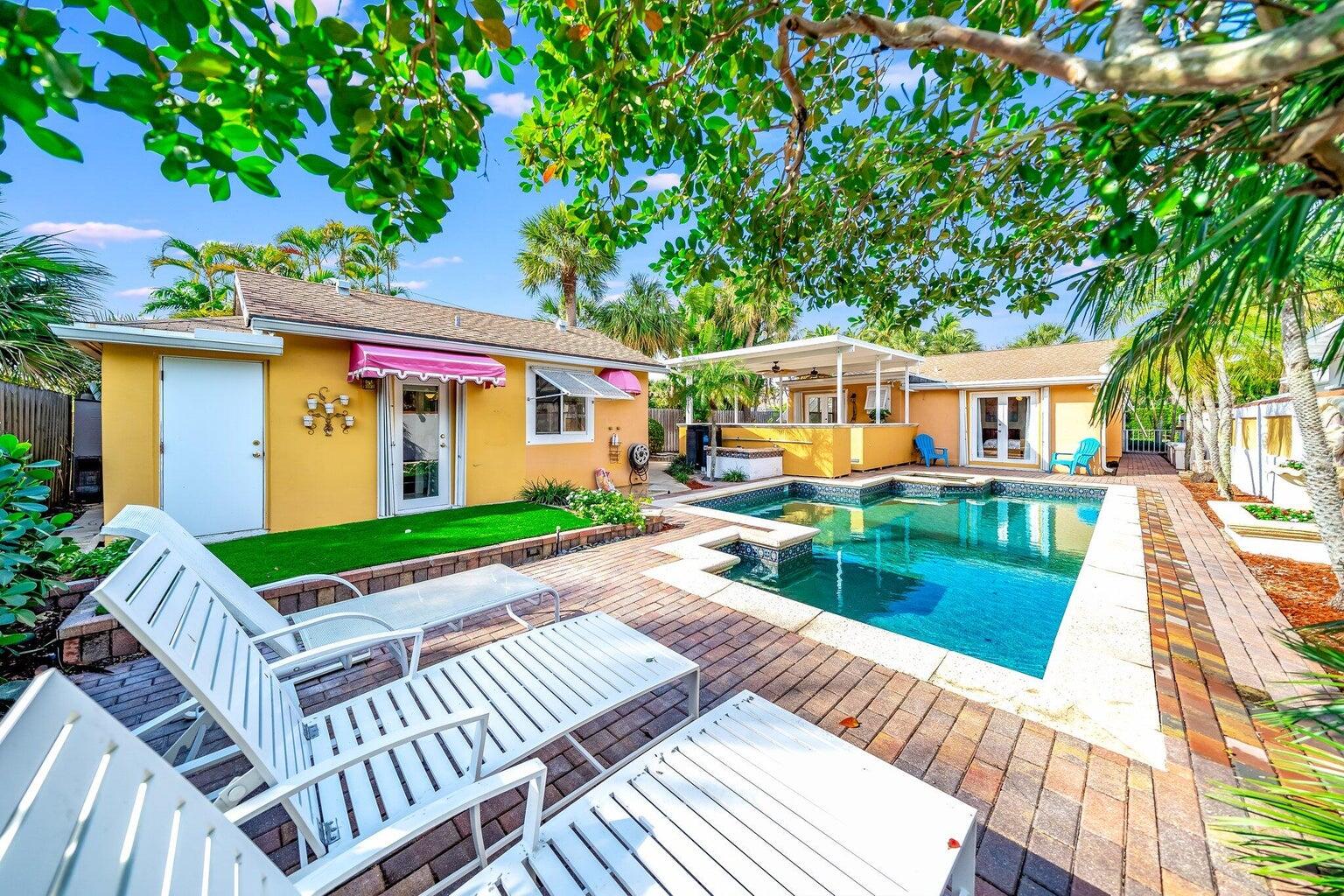 a view of a house with backyard and sitting area