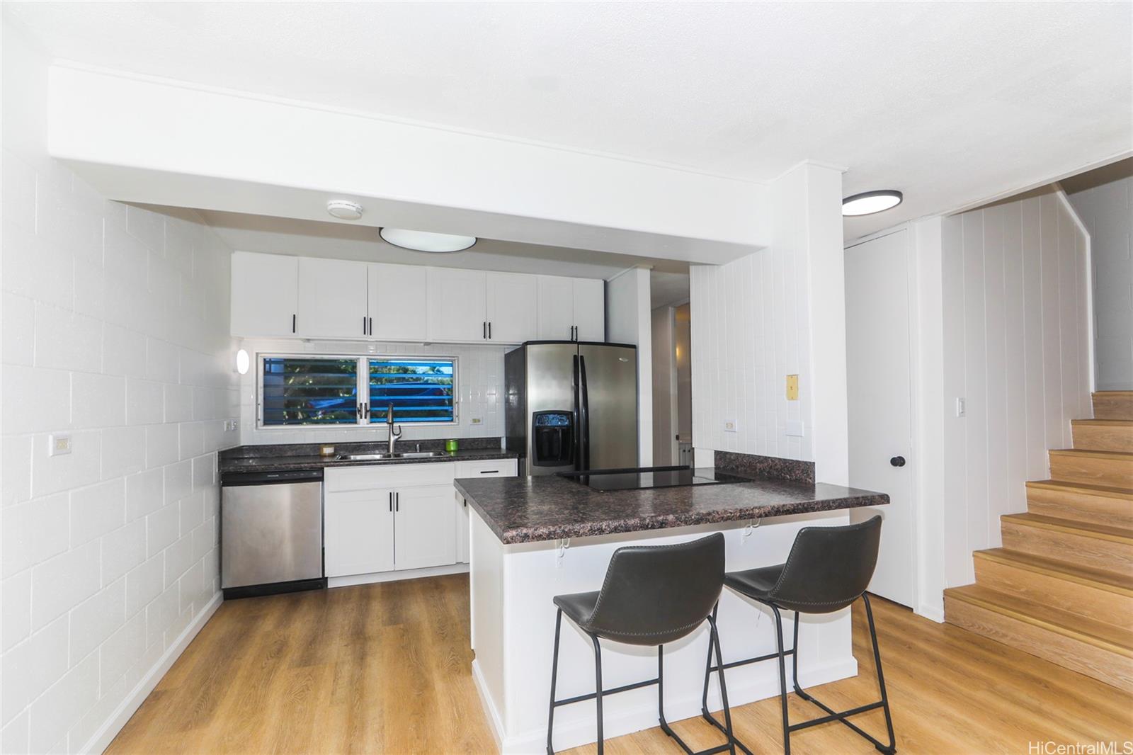 a kitchen with stainless steel appliances granite countertop a sink and a refrigerator