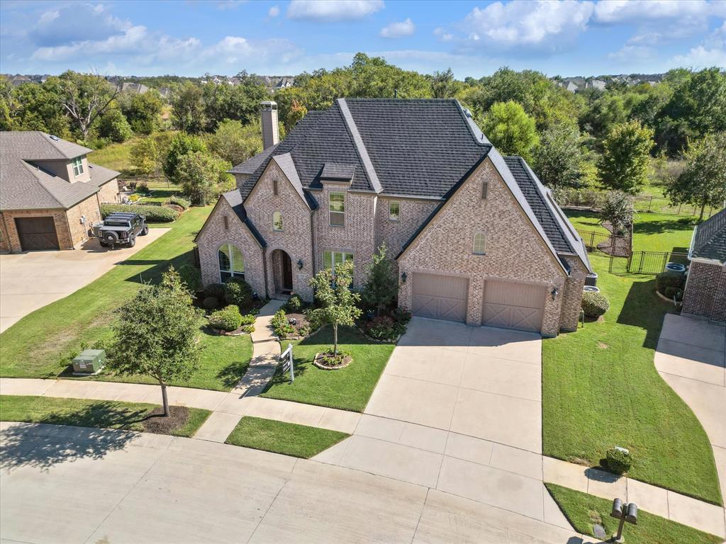 a aerial view of a house with a yard and a large tree