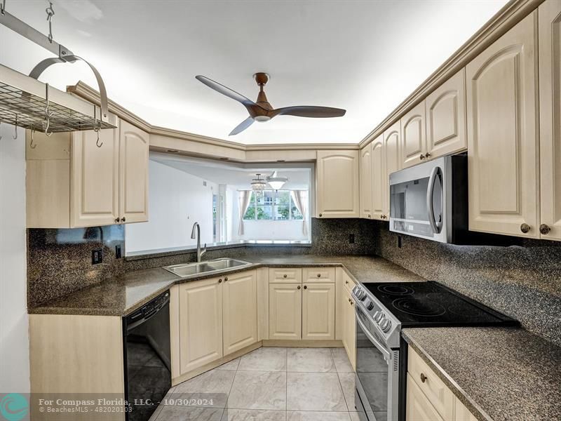 a kitchen with stainless steel appliances granite countertop a sink stove and cabinets