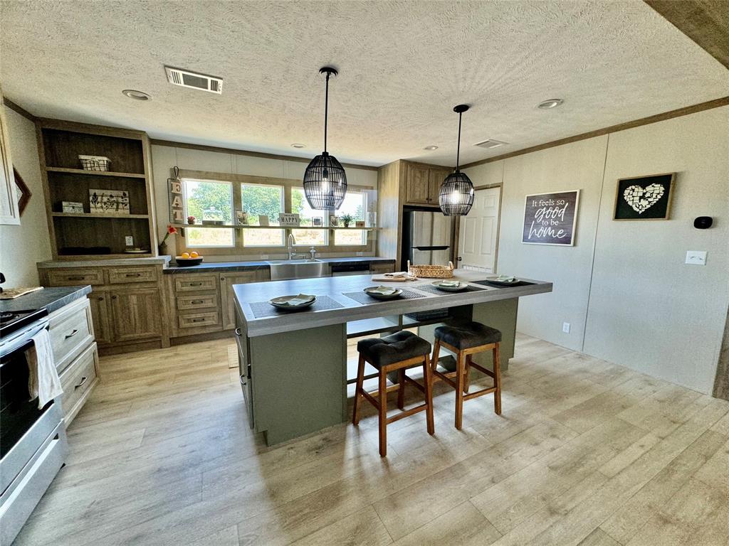 a kitchen with stainless steel appliances granite countertop sink stove top oven and cabinets