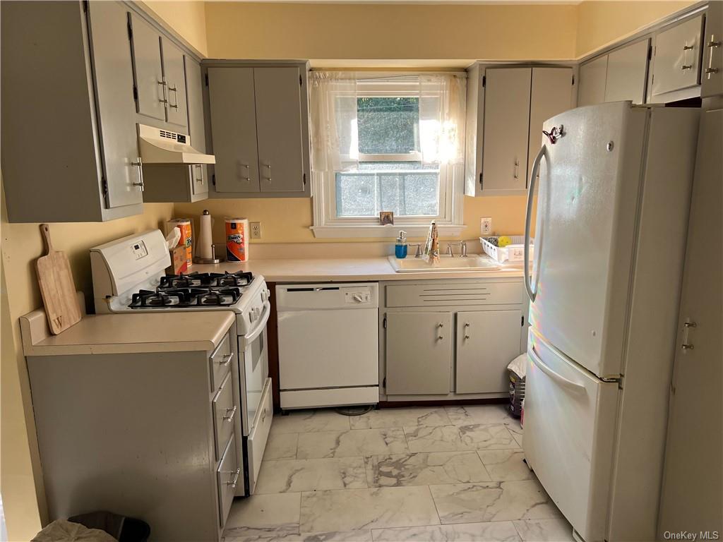 a kitchen with a refrigerator sink stove and cabinets