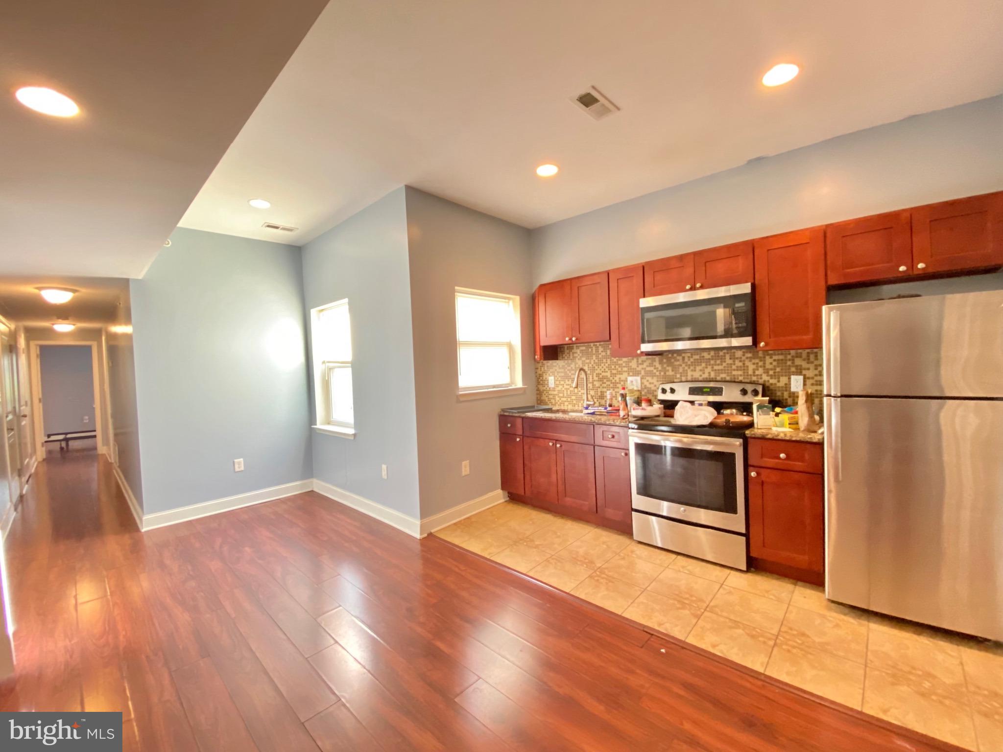 a kitchen with a refrigerator and a stove top oven