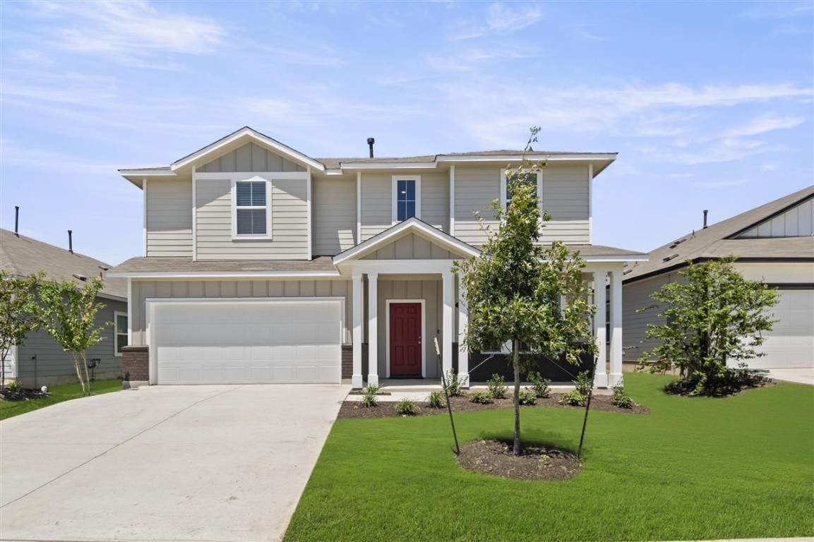 a front view of a house with a yard and garage