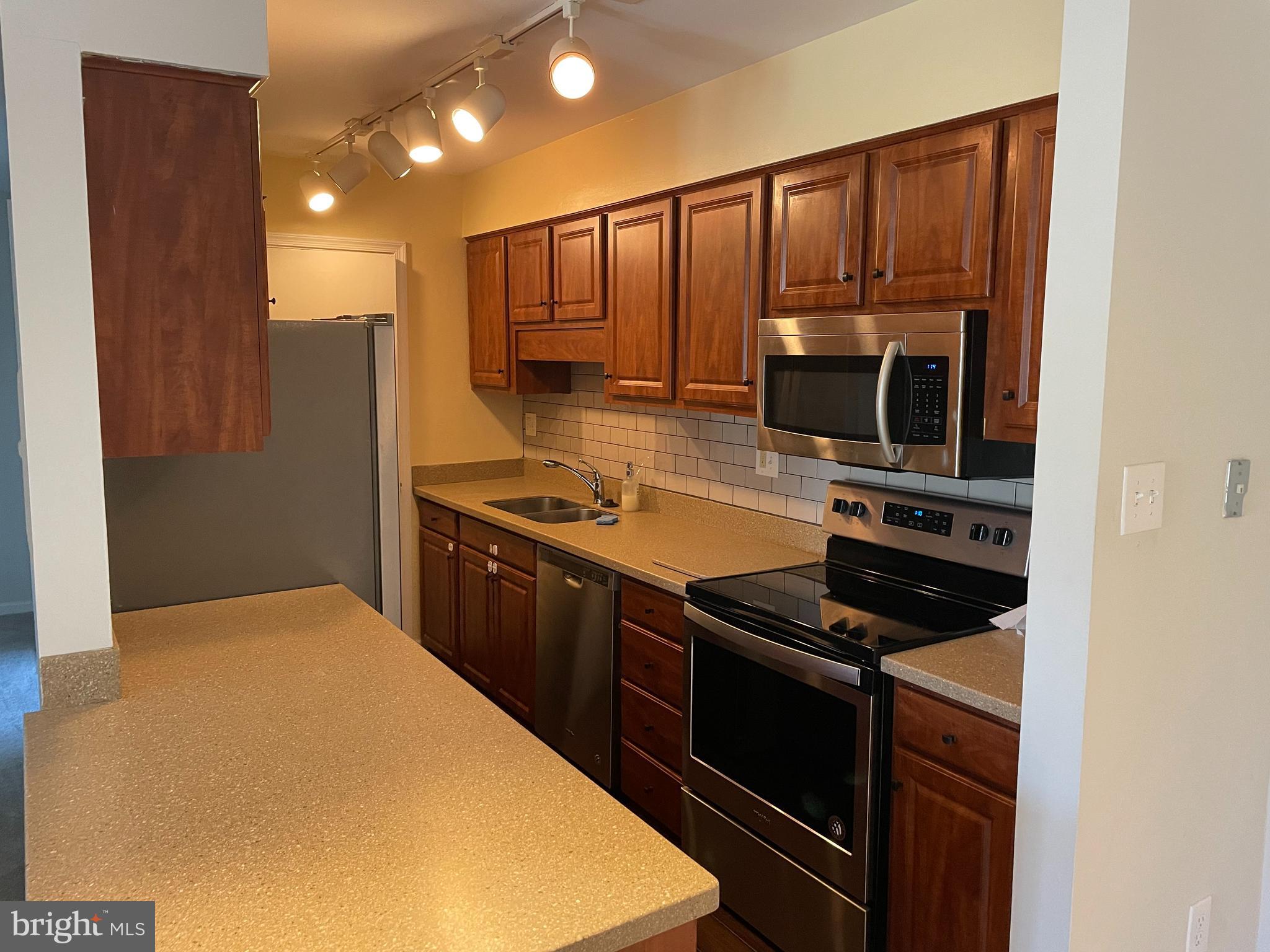 a kitchen with stainless steel appliances a stove a microwave and a refrigerator