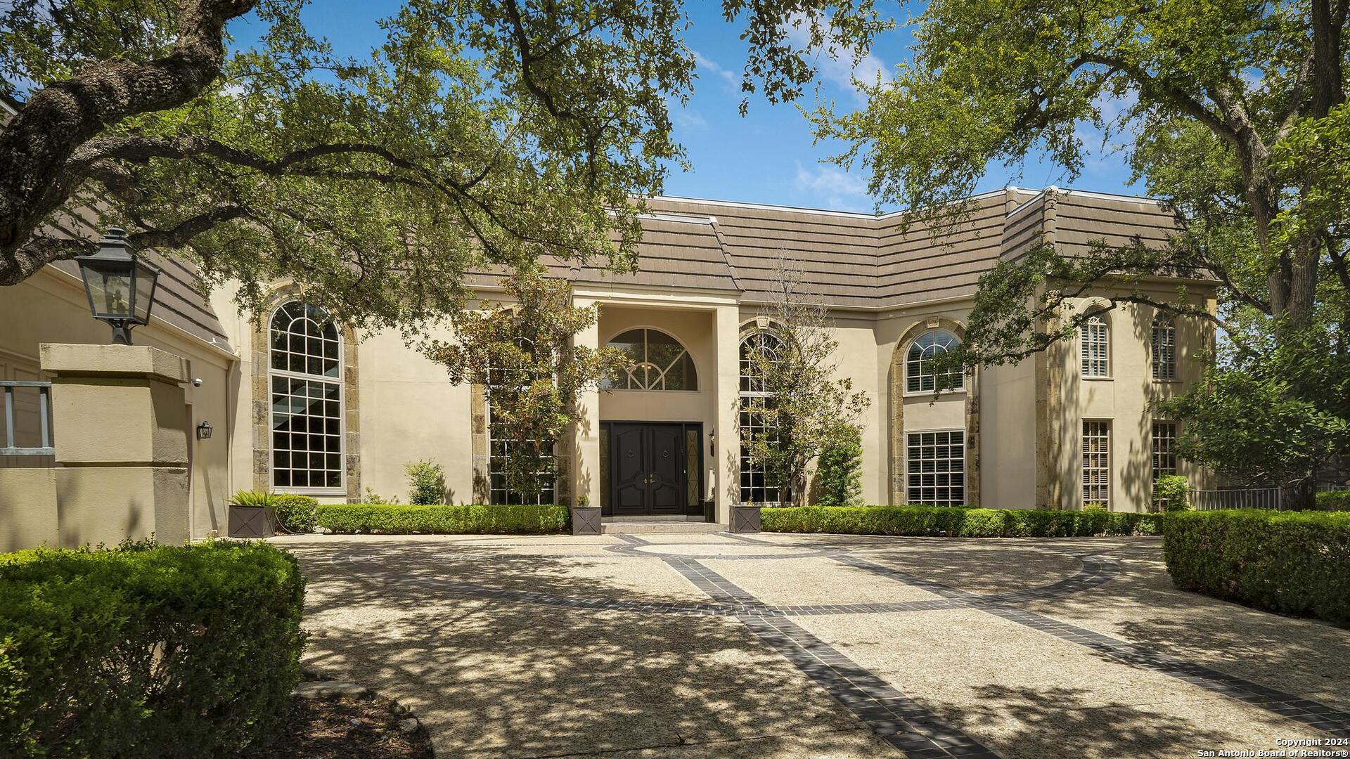 a front view of a house with yard and parking