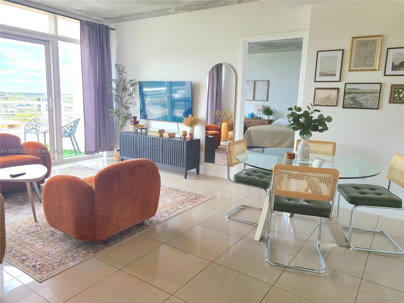 a living room with furniture and a floor to ceiling window