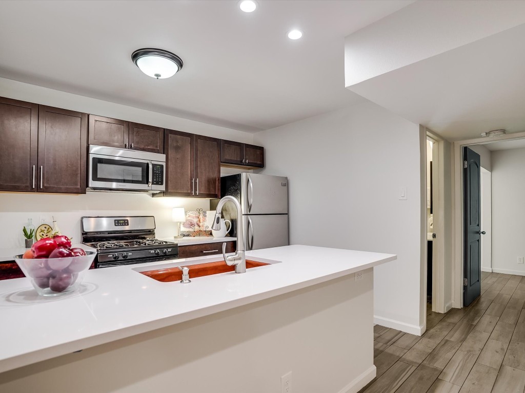 a kitchen with stainless steel appliances a microwave sink refrigerator and cabinets