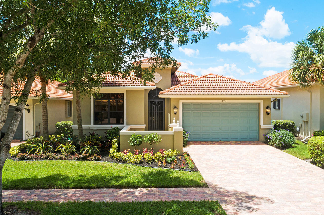 a front view of a house with a garden and plants