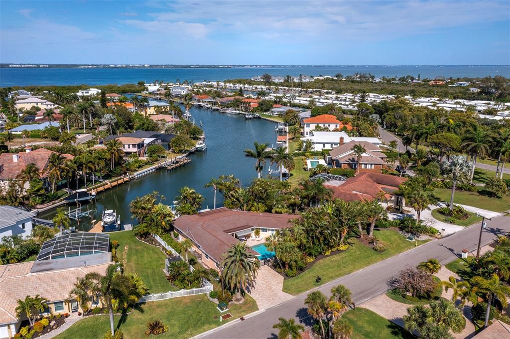 an aerial view of ocean and residential houses with outdoor space