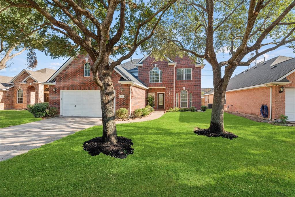 a front view of a house with a yard and tree