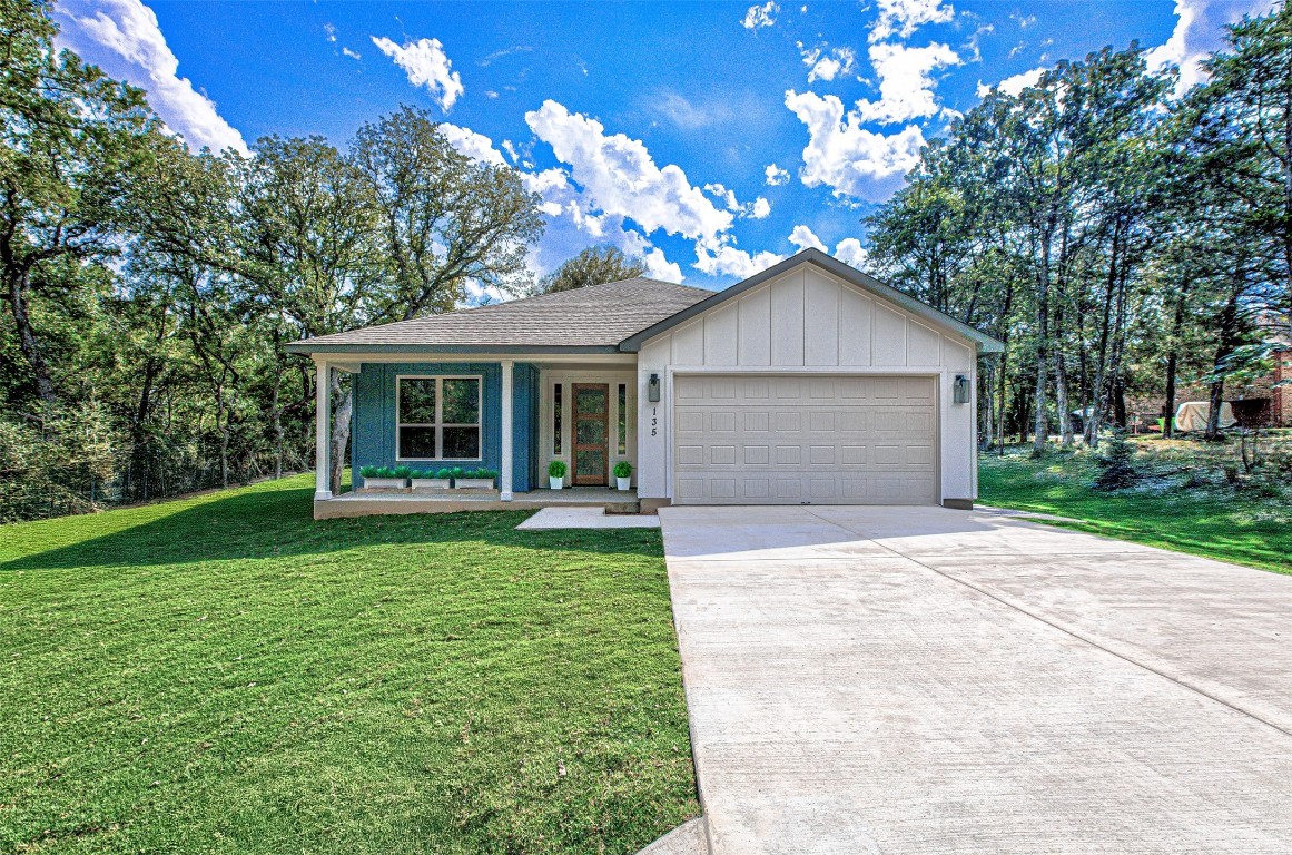 a front view of a house with a garden and yard