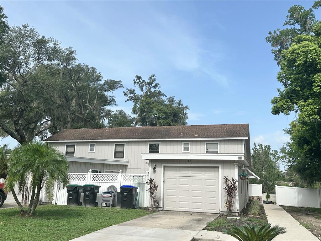 a front view of house with yard and trees in the background