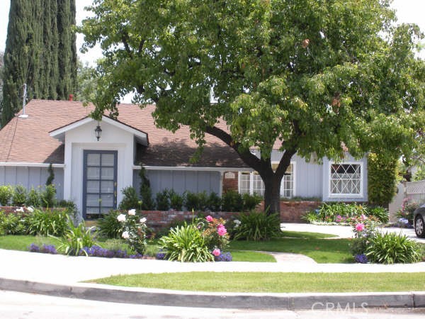 a front view of a house with a yard and potted plants