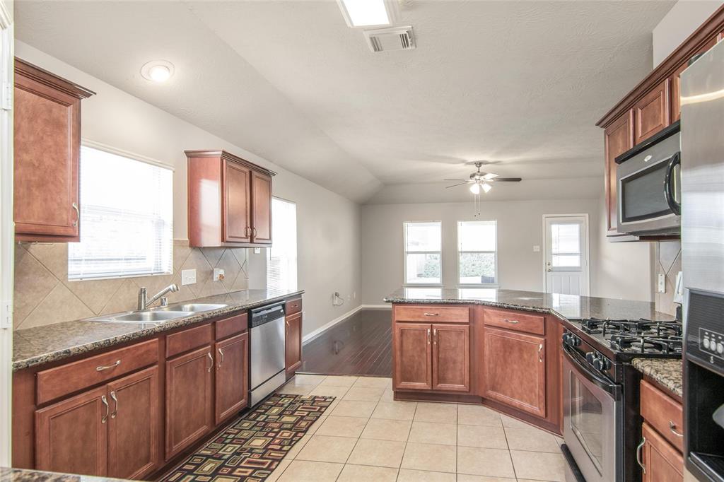 a large kitchen with stainless steel appliances granite countertop a sink stove and cabinets