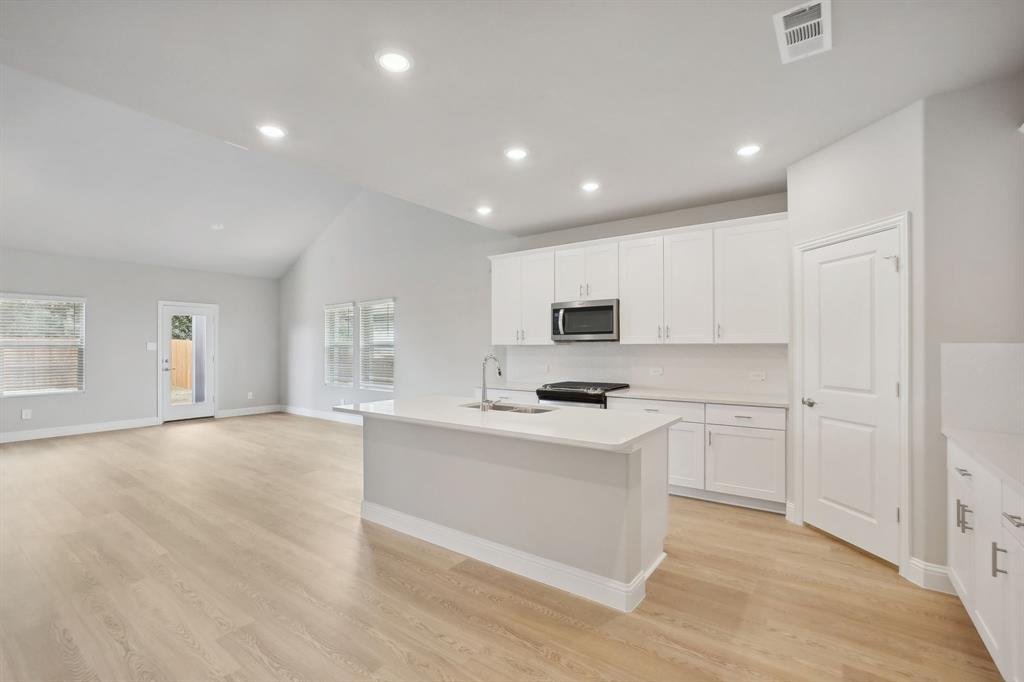 a kitchen with stainless steel appliances a white stove top oven sink and cabinets