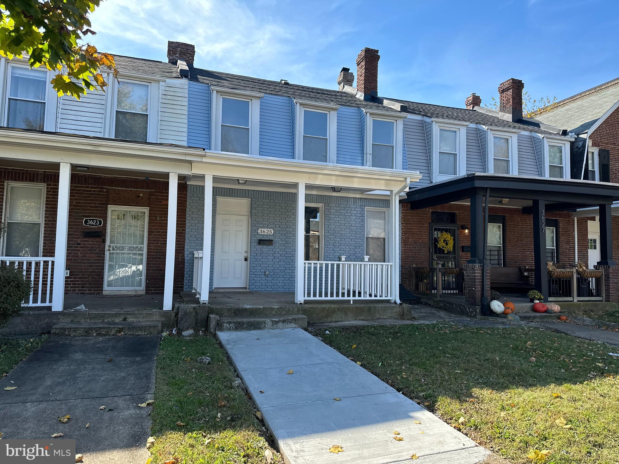 front view of a brick house with a yard