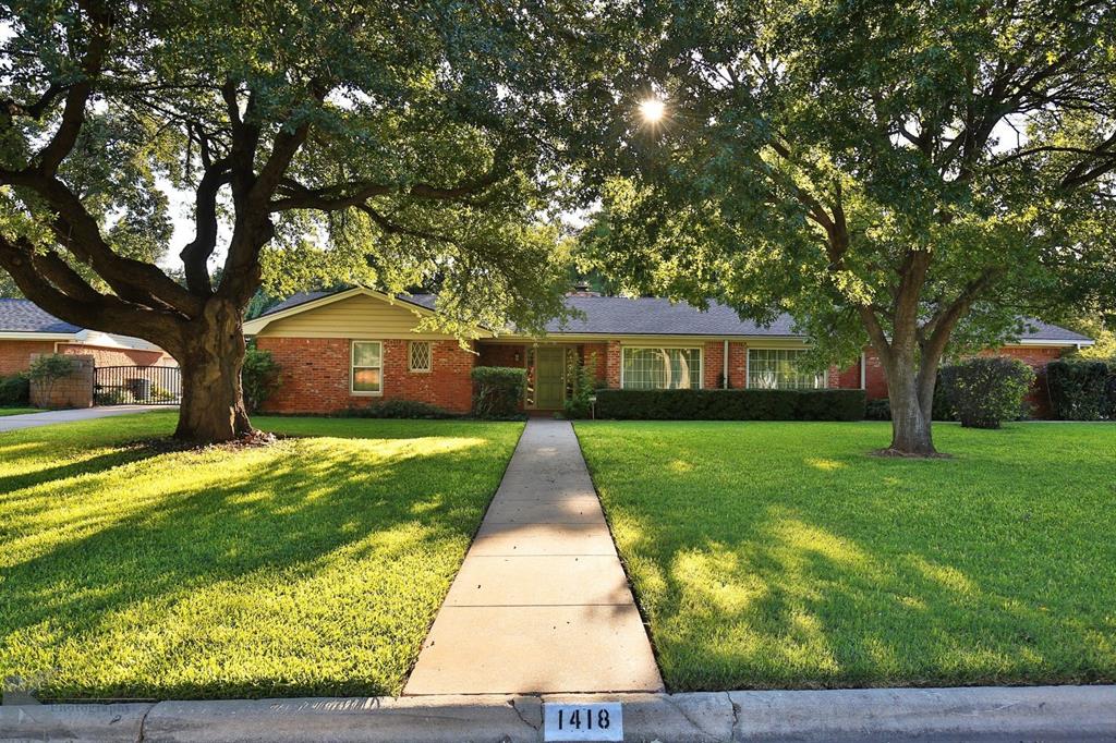 a front view of a house with a garden and trees