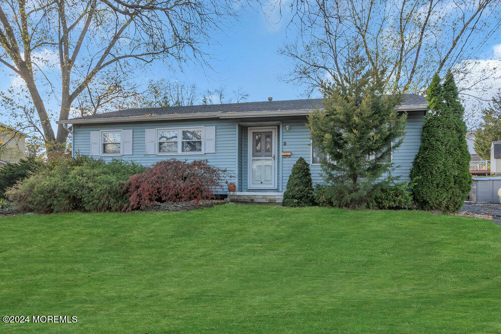 a view of a house with a yard and large trees