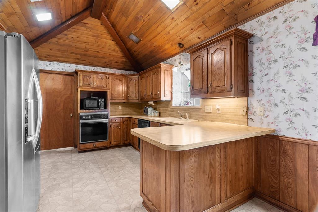 a kitchen with stainless steel appliances granite countertop a sink a refrigerator and a stove