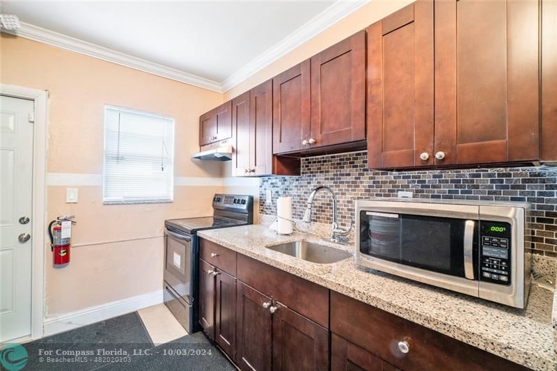 a kitchen with stainless steel appliances granite countertop a sink stove and microwave