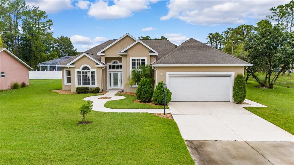 a front view of a house with a yard and trees