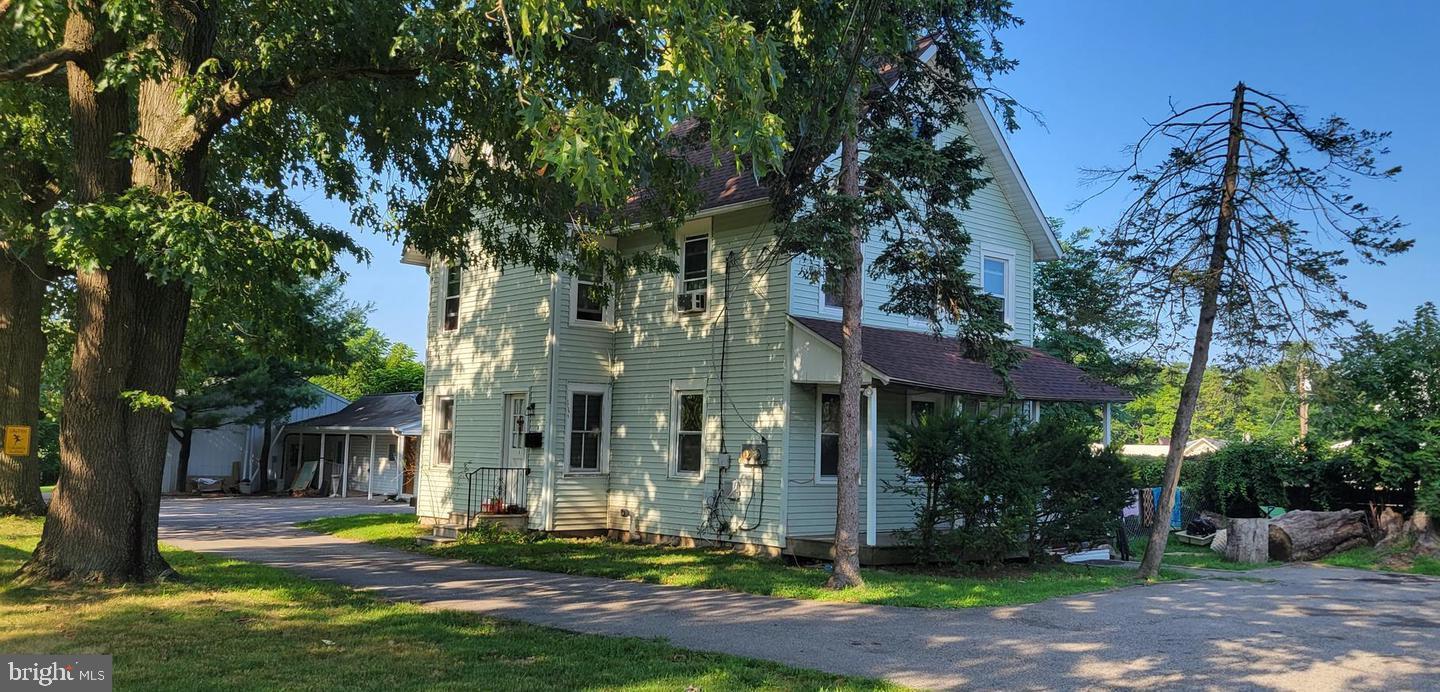 a view of the house with yard and tree s