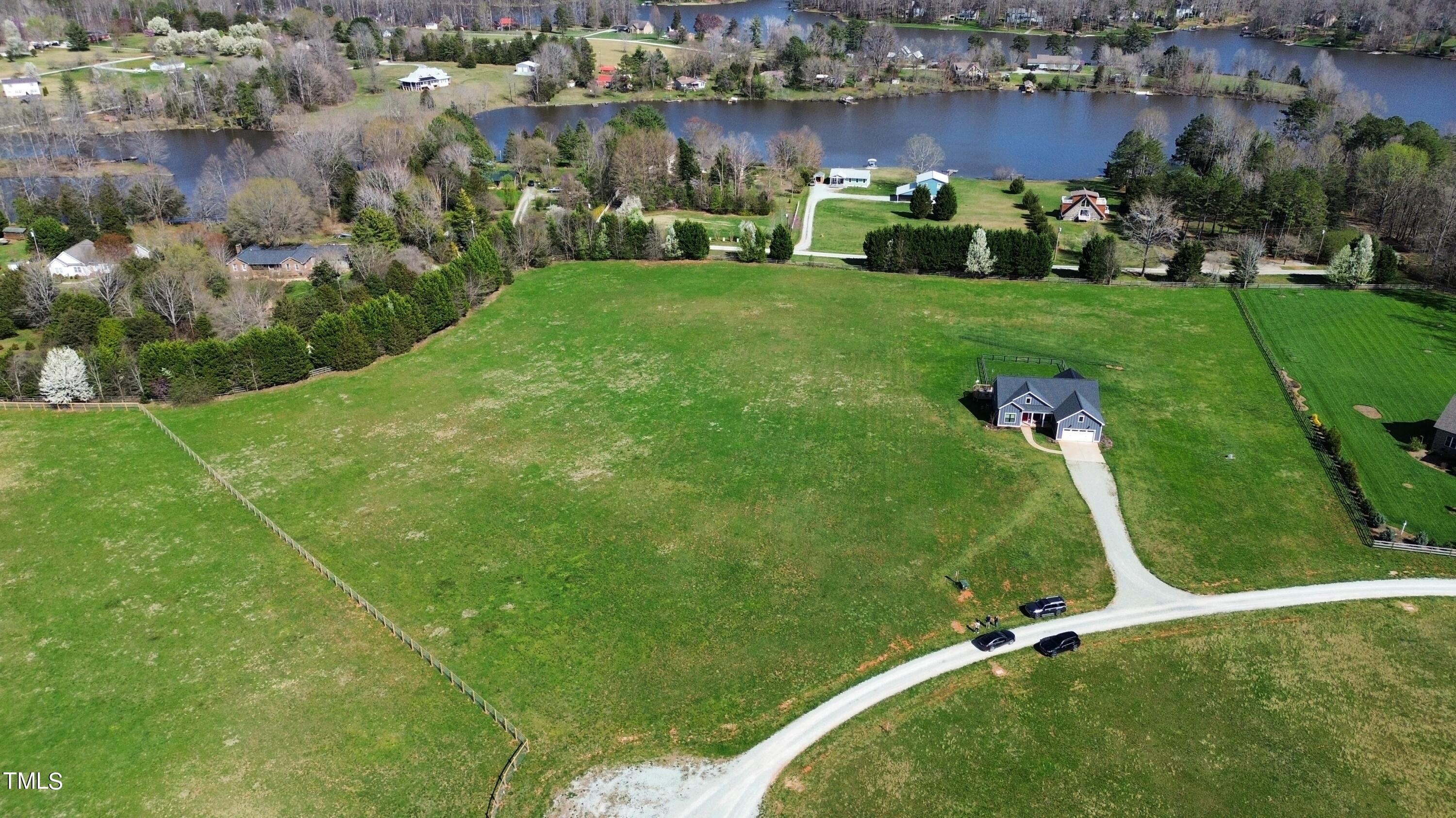 an aerial view of a house with a garden and lake view