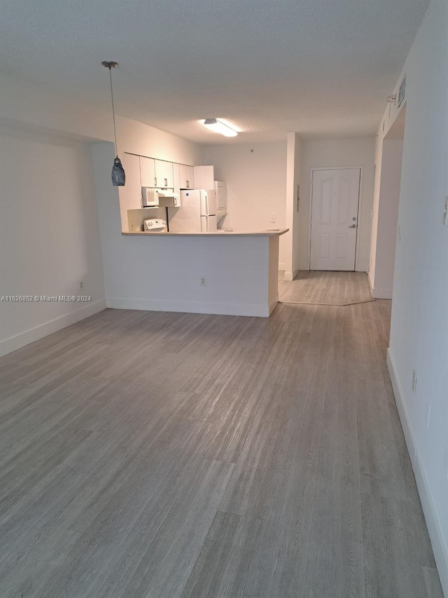 a view of a kitchen with a sink and a refrigerator