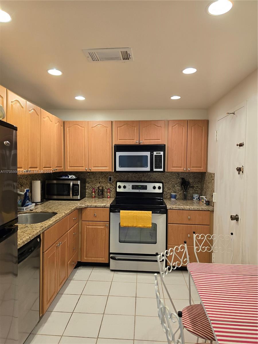 a kitchen with stainless steel appliances granite countertop a sink and cabinets