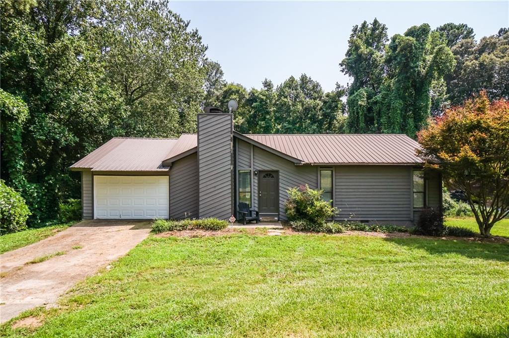 a front view of house with yard and trees around