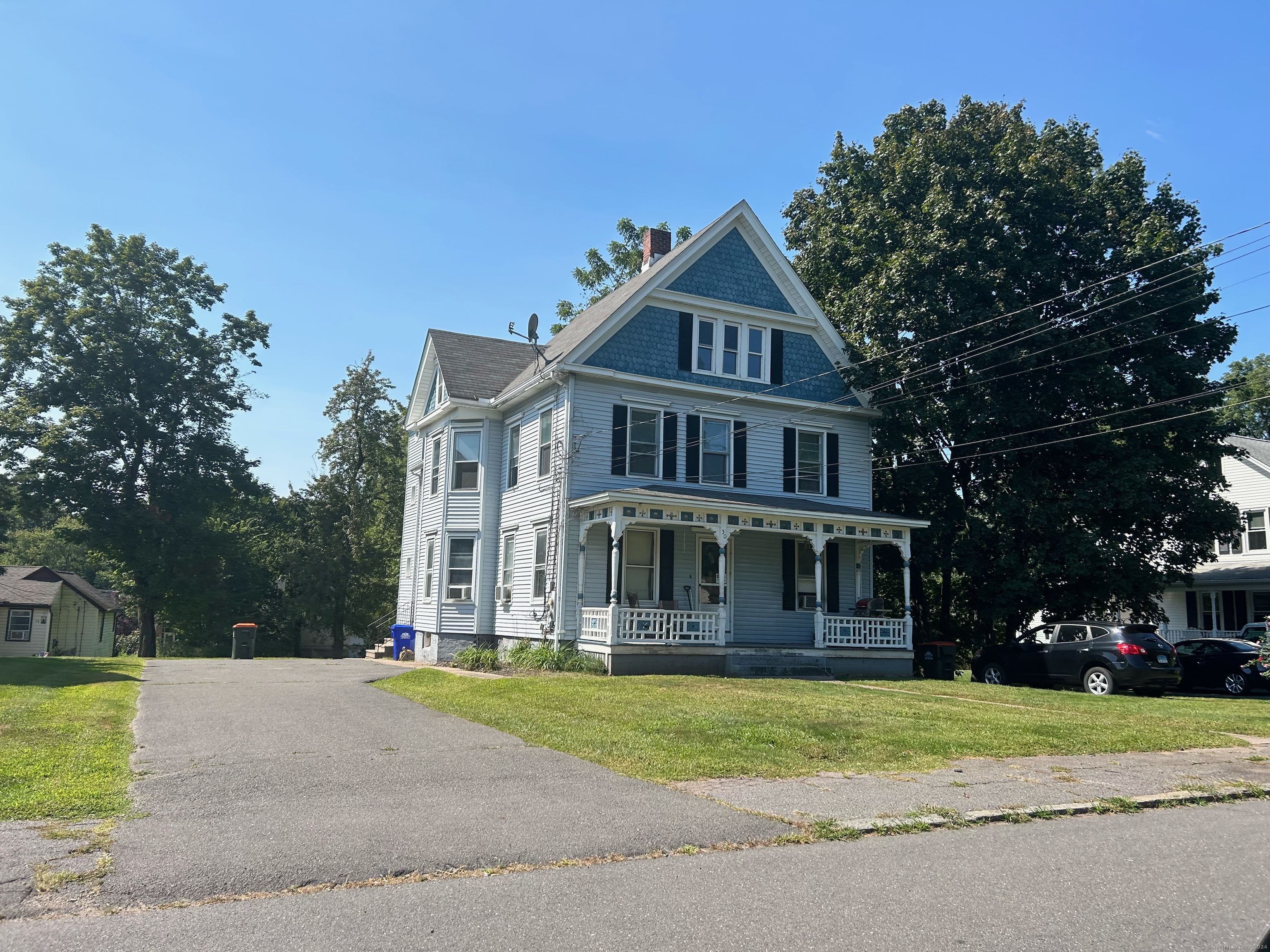 a front view of a house with a yard and trees