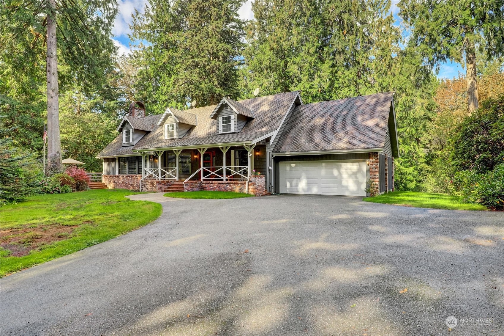 a view of a house with a yard and large tree