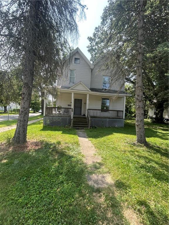 a front view of a house with a yard table and a large tree