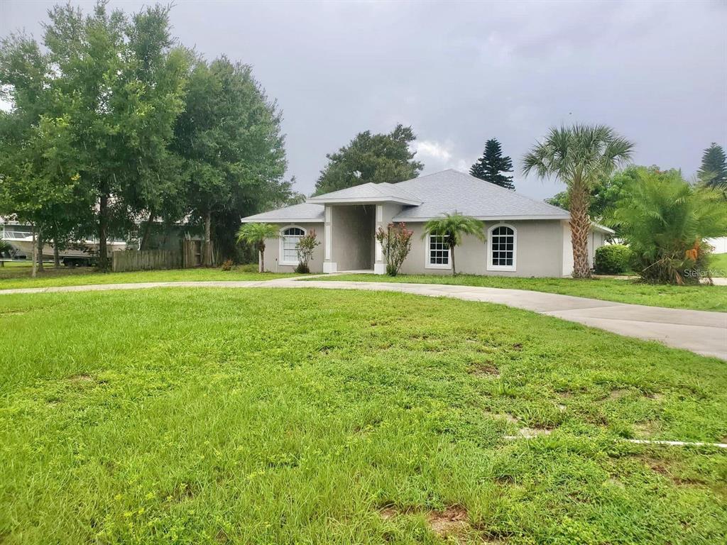 a front view of a house with a yard and trees