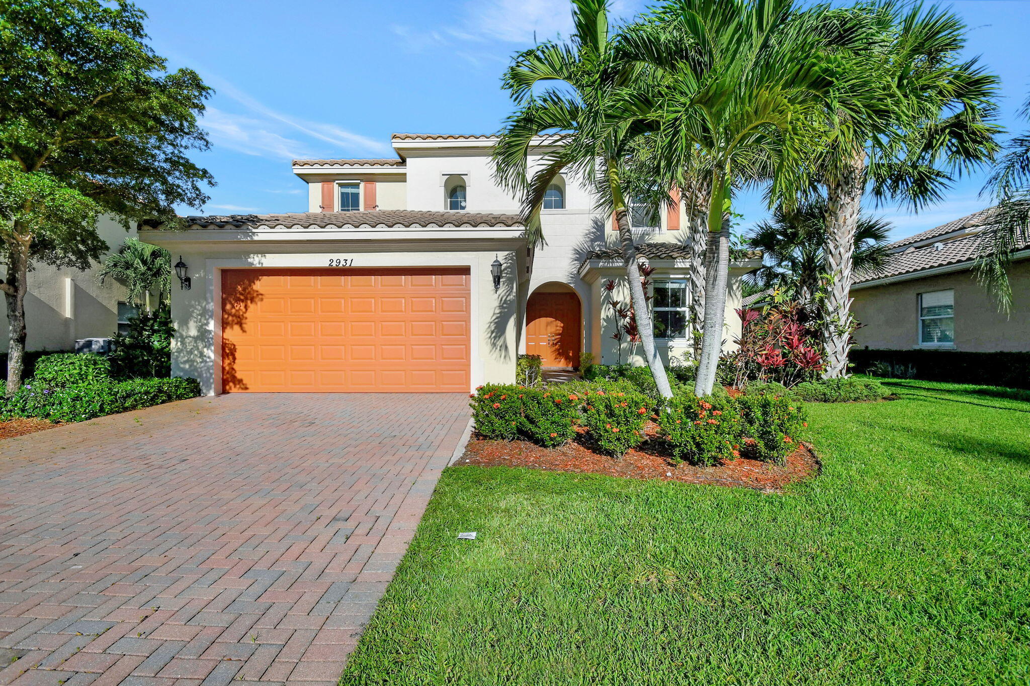 a front view of a house with a garden and plants