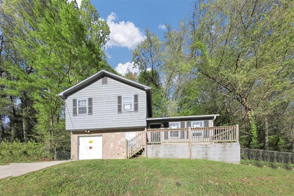 a front view of house with yard and trees in the background