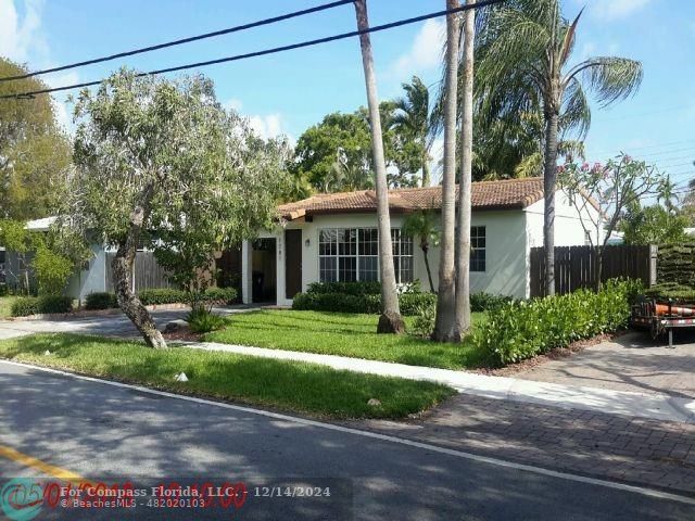 a front view of a house with a yard and green space