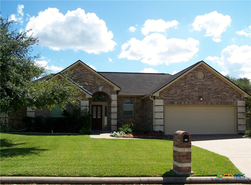 a front view of house with a garden