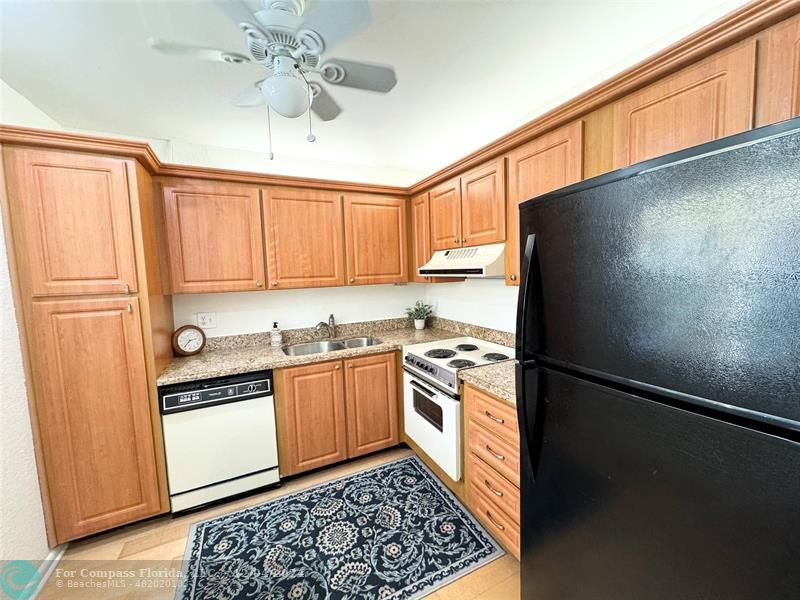 a kitchen with stainless steel appliances granite countertop a refrigerator a sink and dishwasher