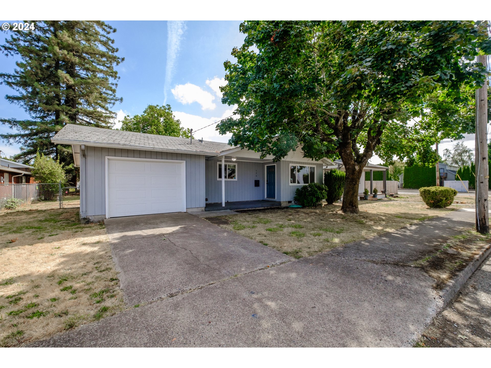 a view of a house with a yard and tree