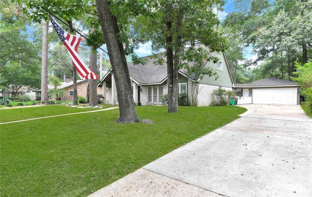 a front view of a house with garden and trees