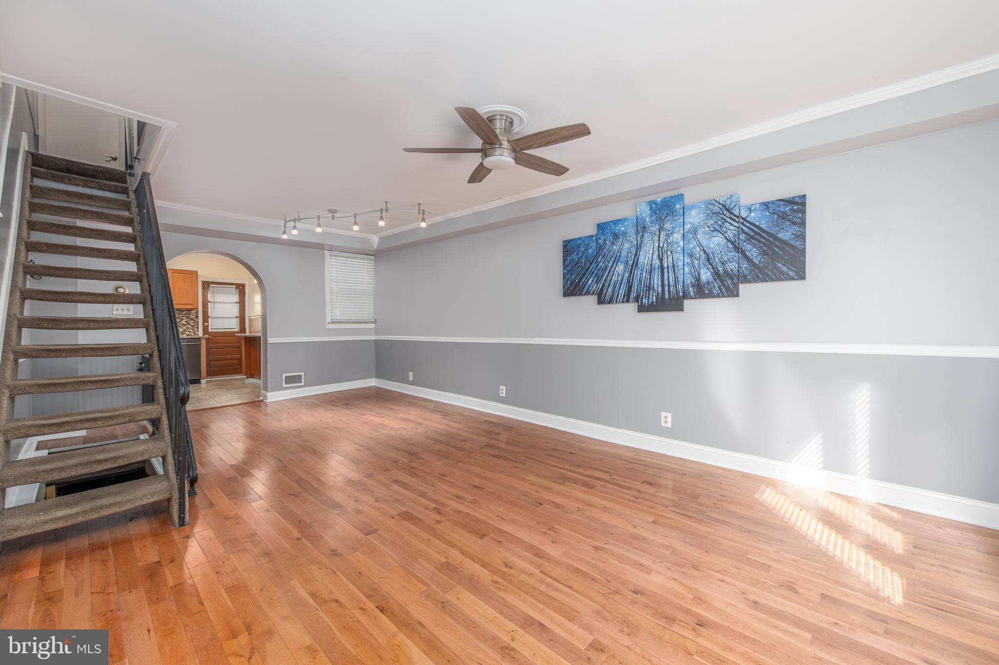 a view of a livingroom with wooden floor and staircase